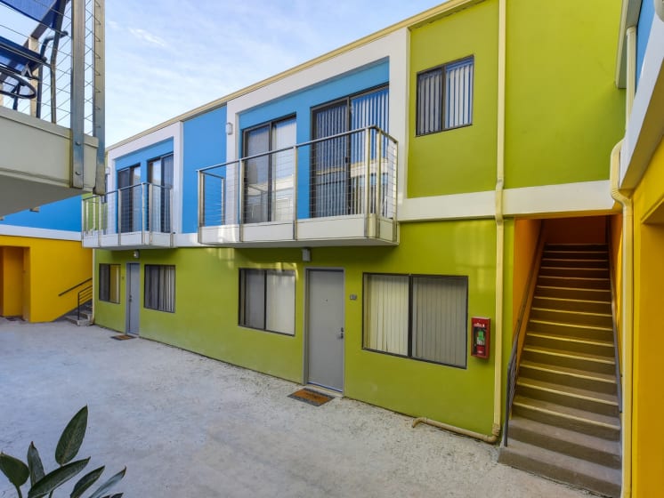 Blue/Yellow/Green  Apartment Exterior with View of Private Patio, Trees